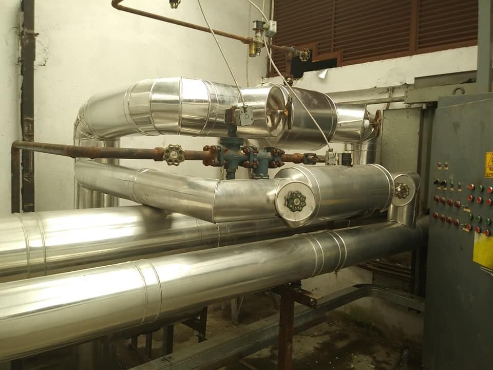 Tuberías industriales forradas en lámina de aluminio natural dentro de una planta